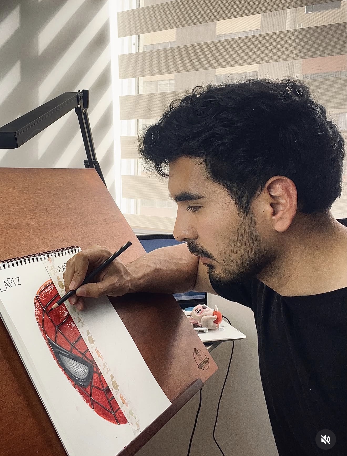 Edison Zárate dibujando a Spider-Man en su mesa de trabajo